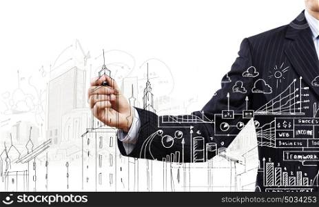 Building business. Close up of businessman drawing business sketches with marker
