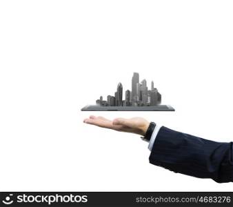 Building business. Close up of human hand holding tablet pc with city image