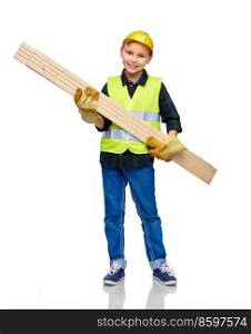 building, carpentry and profession concept - happy smiling little boy in protective helmet, gloves and safety vest with wooden boards over white background. little boy in protective helmet with wooden boards