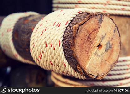 building, construction and eco concept - wooden beam wrapped with rope