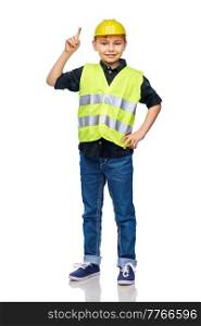 building, construction and profession concept - happy smiling little boy in protective helmet and safety vest pointing finger up over white background. boy in construction helmet pointing finger up
