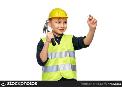 building, construction and profession concept - happy smiling little boy in protective helmet and safety vest with hammer nailing nail over white background. boy in protective helmet with hammer nailing nail