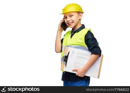 building, construction and profession concept - happy smiling little boy in protective helmet and safety vest with clipboard calling on smartphone over white background. boy in helmet with clipboard calling on phone