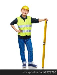 building, construction and profession concept - happy smiling little boy in protective helmet and safety vest with level over white background. boy in construction helmet and vest with level