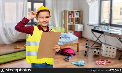 building, construction and profession concept - little boy in protective helmet and safety vest with clipboard over children&rsquo;s room at home background. little boy in construction helmet with clipboard