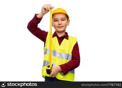 building, construction and profession concept - little boy in protective helmet and safety vest with ruler over white background. boy in construction helmet and vest with ruler