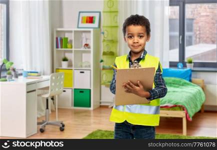 building, construction and profession concept - little boy in safety vest with clipboard over children&rsquo;s room background. little boy in safety vest with clipboard at home