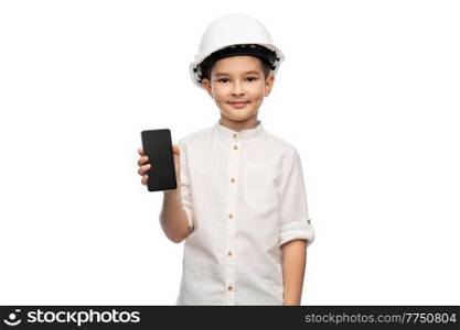 building, construction and profession concept - smiling little boy in helmet showing smartphone over white background. little boy in construction helmet with smartphone