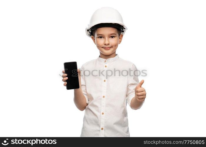 building, construction and profession concept - smiling little boy in helmet showing smartphone over white background. little boy in construction helmet with smartphone