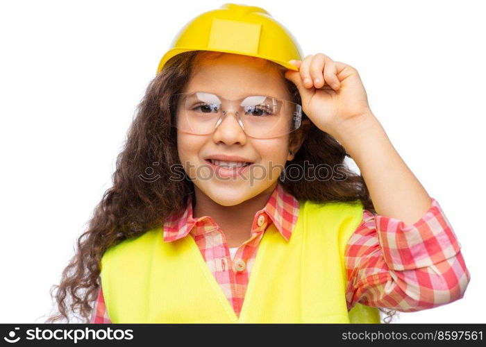 building, construction and profession concept - smiling little girl in goggles, protective helmet and safety vest over white background. little girl in construction helmet and safety vest