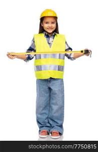 building, construction and profession concept - smiling little girl in protective helmet and safety vest with ruler over white background. little girl in construction helmet with ruler
