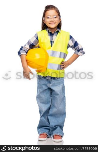 building, construction and profession concept - smiling little girl with protective helmet in safety vest and goggles over white background. happy girl with helmet in safety vest and goggles