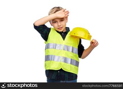 building, construction and profession concept - tired little boy in protective helmet and safety vest over white background. tired boy in protective helmet and safety vest