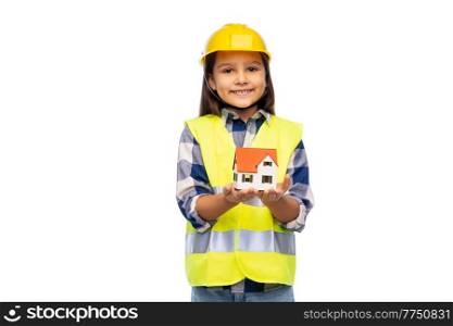building, construction and real estate concept - smiling little girl in protective helmet and safety vest over holding living house model white background. girl in helmet and safety vest holding house