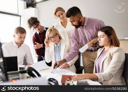 building, construction, architecture, real estate and people concept - business team with blueprint and dividers meeting and discussing house project at office. business team discussing house project at office