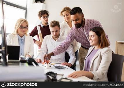 building, construction, architecture, real estate and people concept - business team with blueprint meeting and discussing house project at office. business team discussing house project at office. business team discussing house project at office