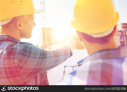 building, construction, development, teamwork and people concept - close up of builders with blueprint at building site