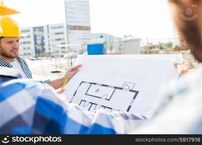 building, construction, development, teamwork and people concept - close up of builders with blueprint at building site
