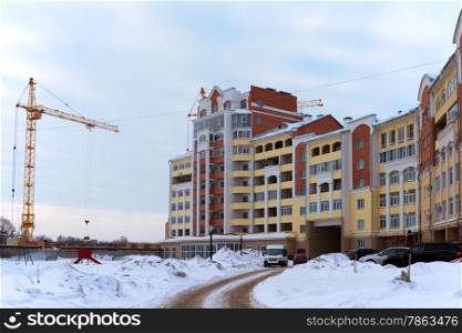 Building crane and building under construction against the white snow&#xA;&#xA;