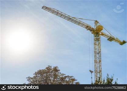 Building crane on construction site with blue sky background