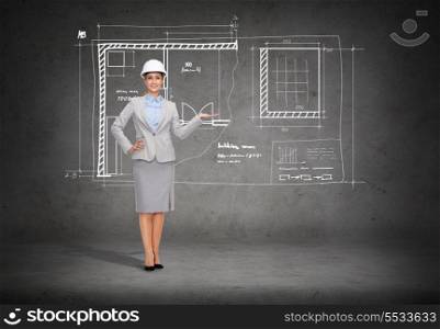 building, developing, advertising and architecture concept - friendly young smiling businesswoman in white helmet showing blueprint