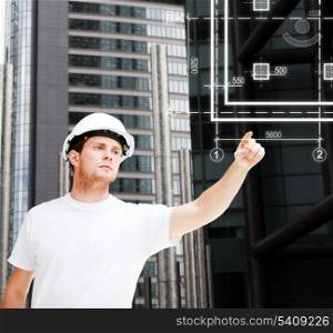 building, developing, consrtuction and architecture concept - male architect in helmet pointing to blueprint on virtual screen