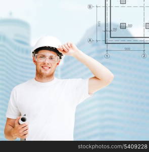 building, developing, consrtuction and architecture concept - male architect in helmet with blueprint and safety glasses