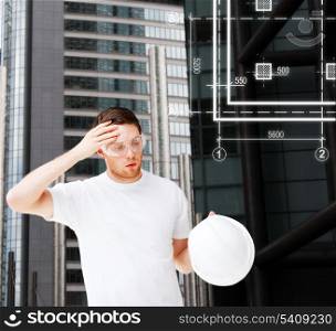 building, developing, consrtuction and architecture concept - male architect in safety glasses taking off helmet