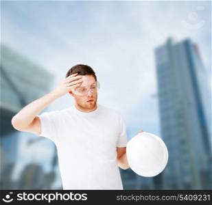 building, developing, consrtuction and architecture concept - picture of male architect in safety glasses taking off helmet