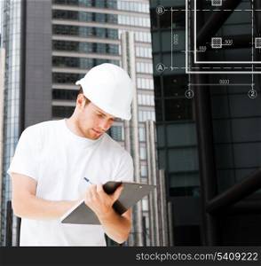 building, developing, consrtuction and architecture concept - picture of male architect in helmet looking at blueprint