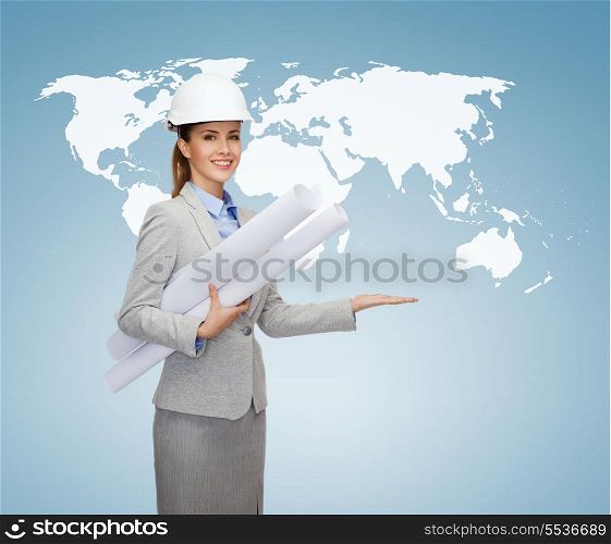 building, developing, consrtuction and architecture concept - smiling architect in helmet with blueprints showing world map on palm of hand