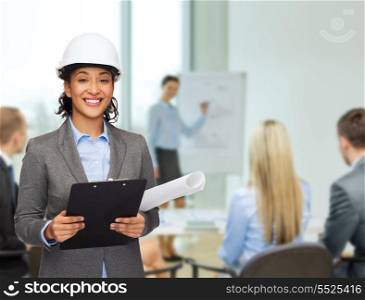 building, developing, consrtuction and architecture concept - smiling businesswoman in white helmet with clipboard and blueprint at office