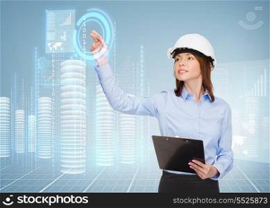 building, developing, consrtuction and architecture concept - smiling businesswoman in white helmet with clipboard pointing finger