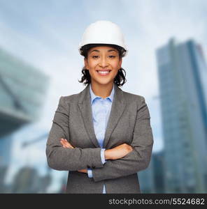 building, developing, consrtuction and architecture concept - smiling businesswoman in white helmet with crossed arms