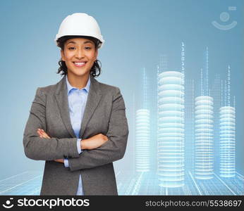 building, developing, consrtuction and architecture concept - smiling businesswoman in white helmet with crossed arms