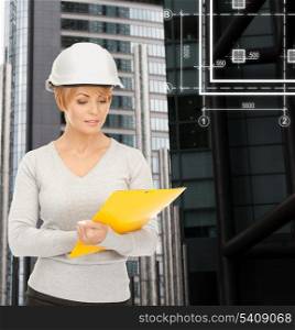 building, developing, consrtuction, architecture concept - female contractor in white helmet with blueprint