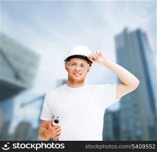 building, developing, consrtuction, architecture concept - male architect in helmet with blueprint and safety glasses