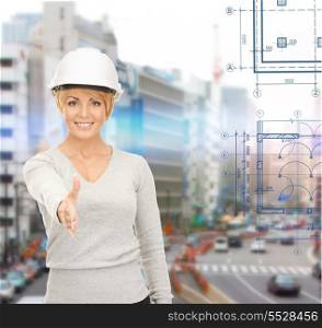 building, developing, construction and architecture concept - female contractor in helmet ready for handshake