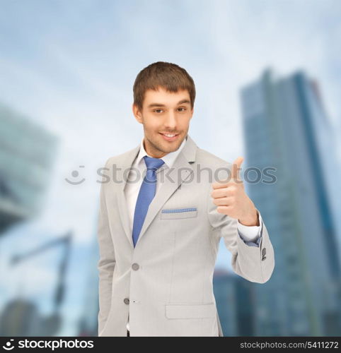 building, developing, construction and architecture concept - handsome man showing thumbs up