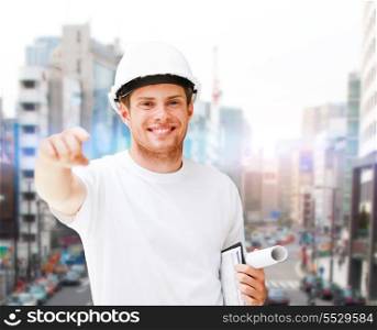 building, developing, construction and architecture concept - male architect in helmet pointing at you