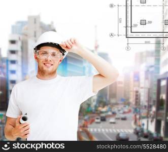 building, developing, construction and architecture concept - male architect in helmet with blueprint and safety glasses