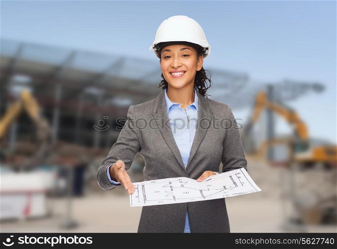 building, developing, construction and architecture concept - smiling african american businesswoman in white helmet showing blueprint