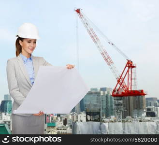 building, developing, construction and architecture concept - smiling businesswoman in white helmet looking at blueprint