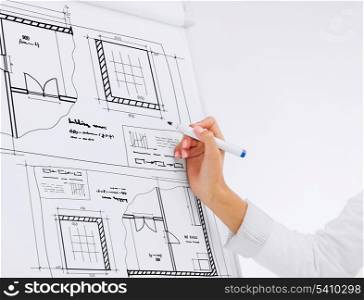 building, developing, office and architecture concept - businesswoman drawing bluepring on flip board in office
