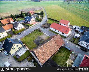 Building development with single-family houses on the edge of a village near Wolfsburg, Germany, aerial view with drone, with fields and meadows in the background, oblique shooting angle