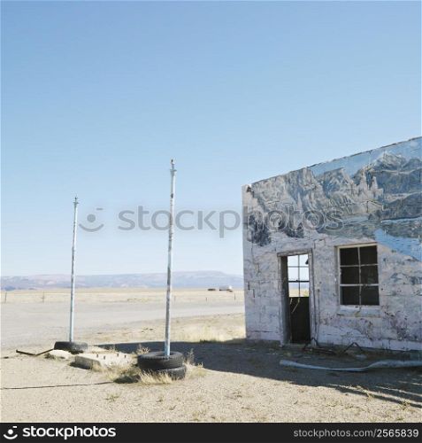 Building in barren desert landscape with winter scene mural painted on side.