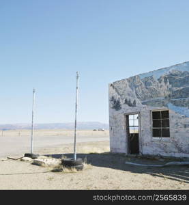 Building in barren desert landscape with winter scene mural painted on side.