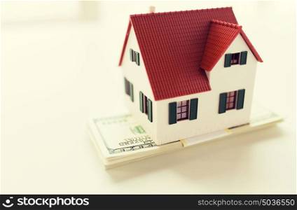 building, mortgage, investment, real estate and property concept - close up of home or house model and money. close up of home or house model and money