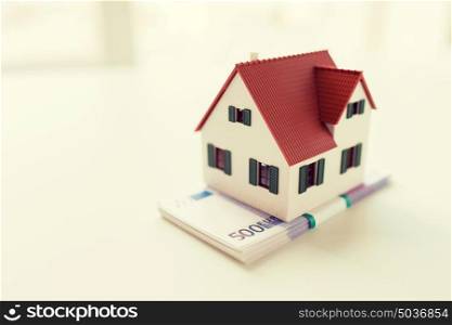 building, mortgage, investment, real estate and property concept - close up of home or house model and money. close up of home or house model and money