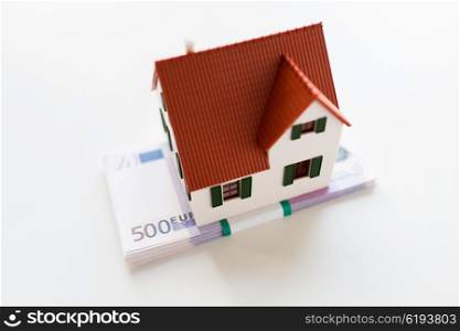 building, mortgage, investment, real estate and property concept - close up of home or house model and money